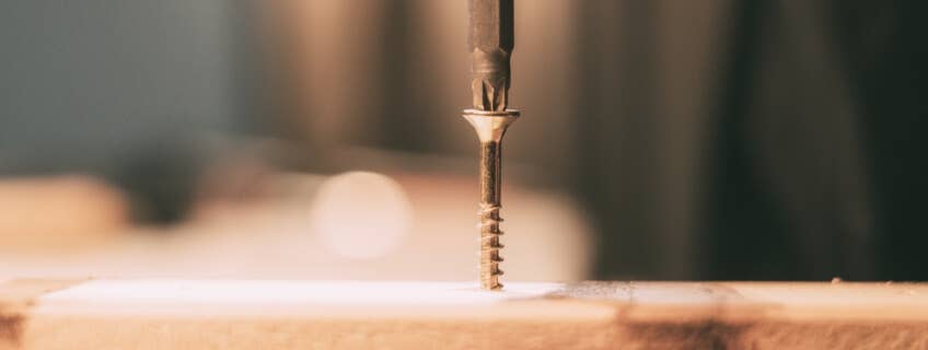 Wood screw being drilled into a piece of wood